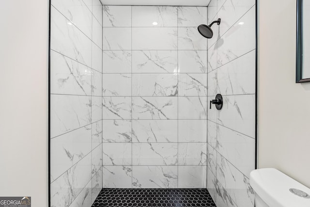 bathroom with tiled shower and toilet