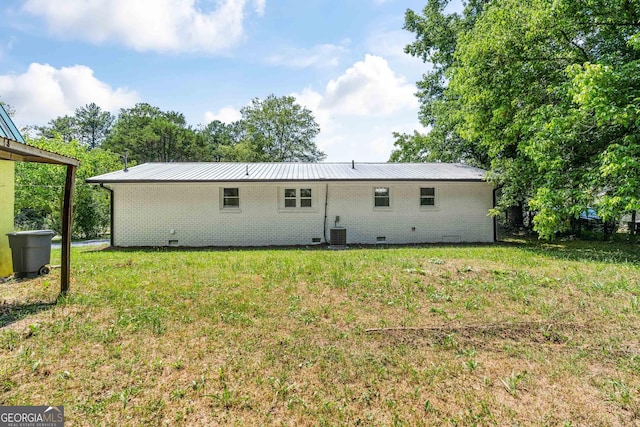 back of house with a lawn and central air condition unit