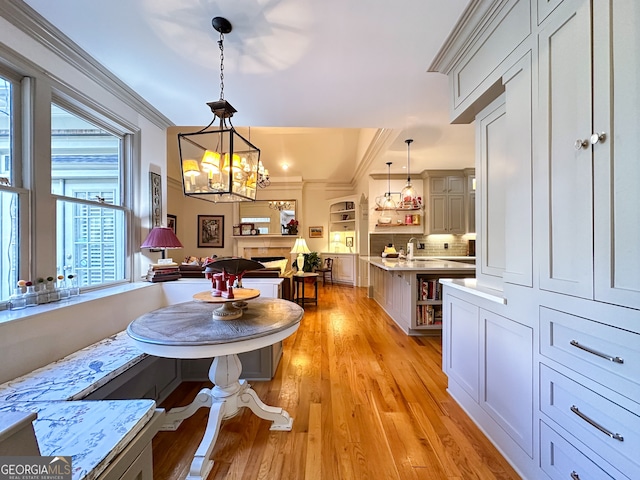 dining area with ornamental molding, light hardwood / wood-style floors, breakfast area, and sink