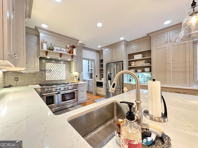 kitchen with decorative backsplash, decorative light fixtures, high end appliances, crown molding, and sink