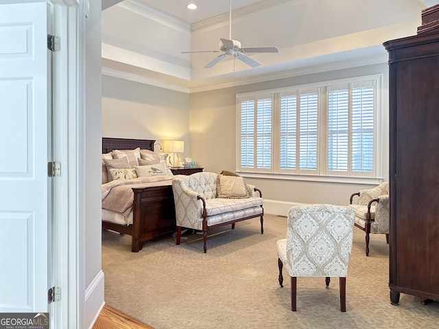 carpeted bedroom featuring ceiling fan, crown molding, and a tray ceiling