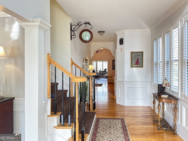 entrance foyer with ornamental molding and light hardwood / wood-style flooring