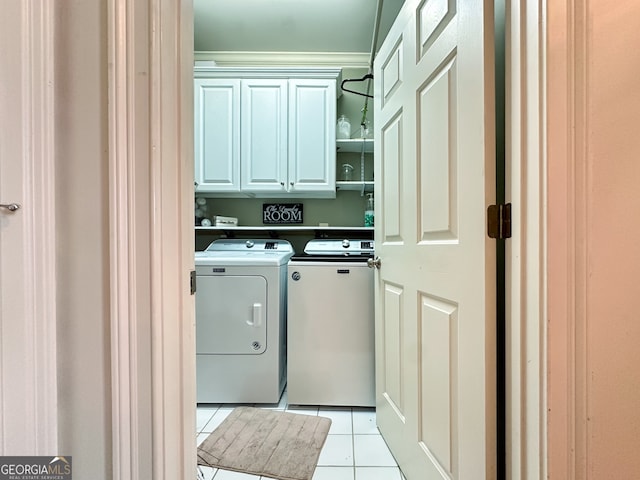 washroom featuring cabinets, light tile patterned floors, and washing machine and dryer