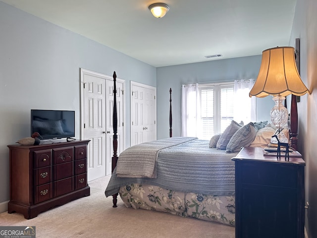 carpeted bedroom with multiple closets