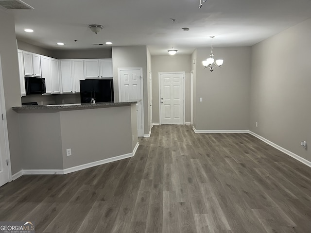 kitchen featuring white cabinetry, dark wood-type flooring, a notable chandelier, kitchen peninsula, and black appliances