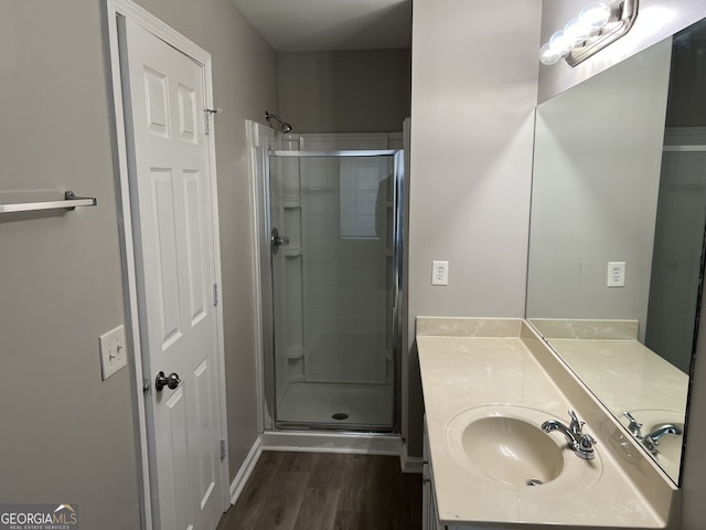 bathroom featuring hardwood / wood-style flooring, vanity, and an enclosed shower