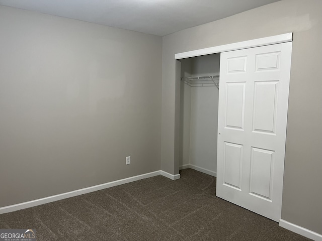 113 Ellis Dr, Conyers, GA 30012 - unfurnished bedroom featuring dark carpet and a closet