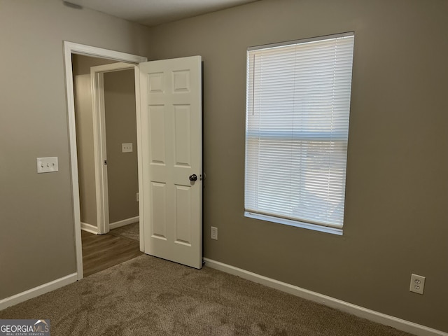 unfurnished bedroom featuring carpet floors and multiple windows