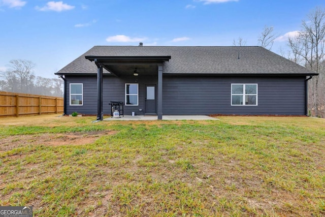 back of property with ceiling fan, a yard, and a patio