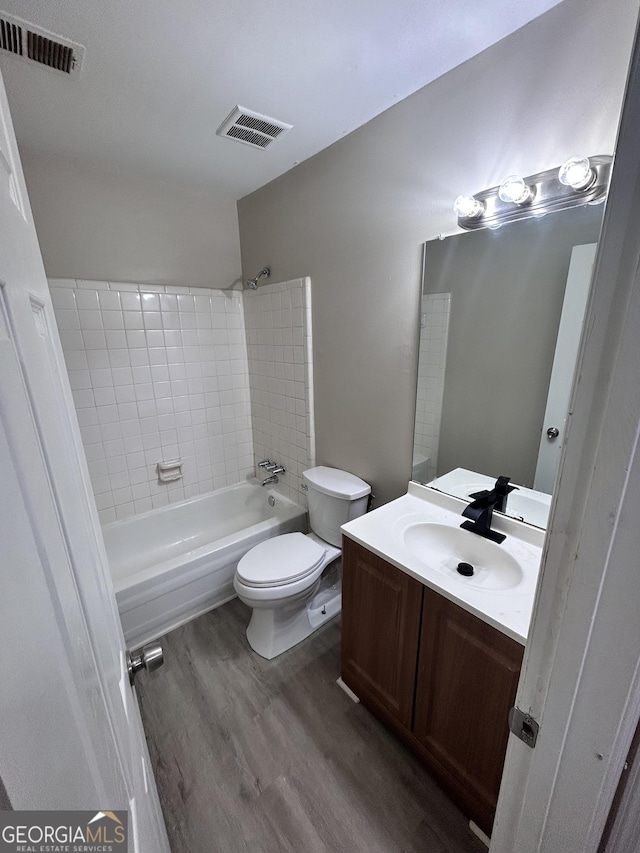 full bathroom with wood-type flooring, vanity, toilet, and tiled shower / bath