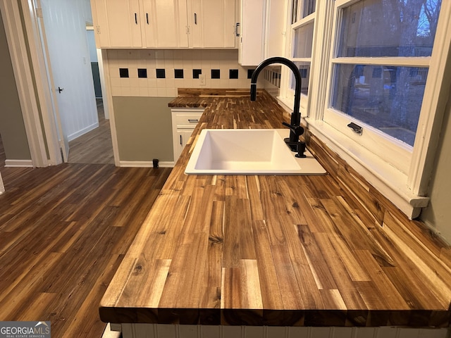 room details featuring white cabinetry, sink, wooden counters, dark hardwood / wood-style floors, and decorative backsplash