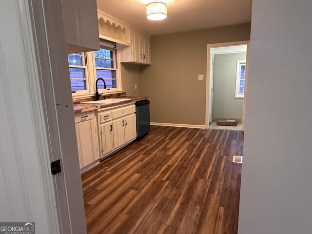 kitchen featuring dark hardwood / wood-style flooring, white cabinetry, sink, and black dishwasher