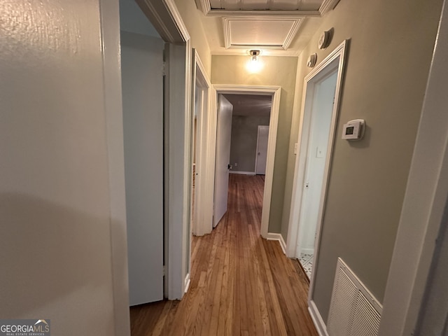 hall featuring crown molding and hardwood / wood-style flooring