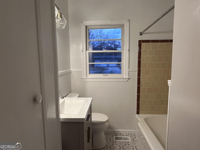 full bathroom with tile patterned floors, tiled shower / bath, vanity, and toilet