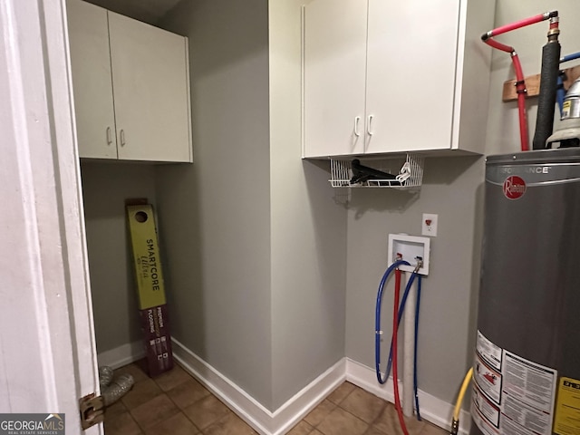 clothes washing area featuring washer hookup, tile patterned flooring, gas water heater, and cabinets