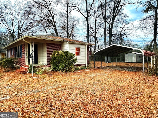 view of home's exterior with a storage unit and a carport