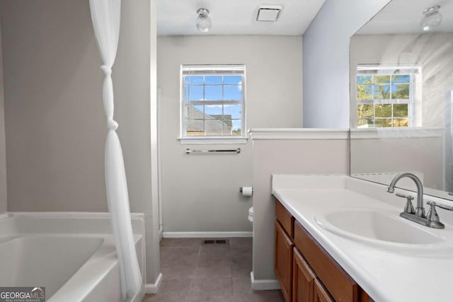 bathroom with tile patterned floors, vanity, a bath, and toilet