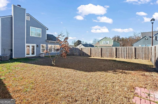 view of yard featuring central air condition unit and french doors