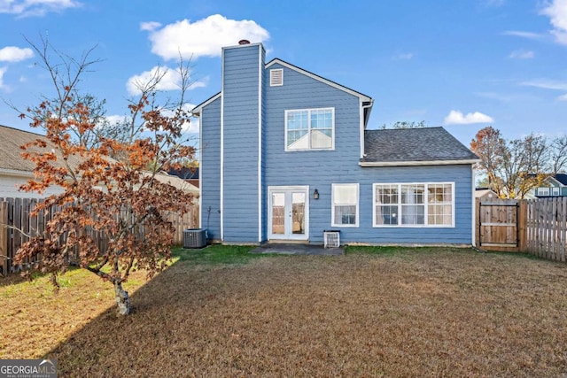 back of property featuring french doors and a lawn