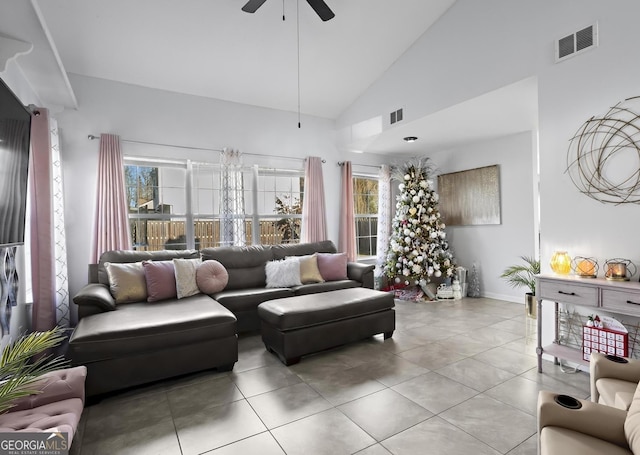 living room with a wealth of natural light, ceiling fan, high vaulted ceiling, and light tile patterned flooring