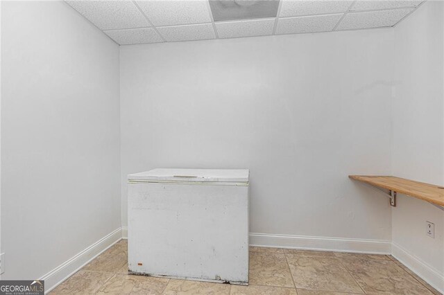 spacious closet with a drop ceiling and light tile patterned flooring