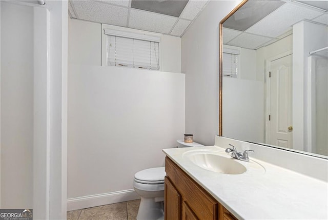 bathroom featuring vanity, a paneled ceiling, tile patterned floors, and toilet