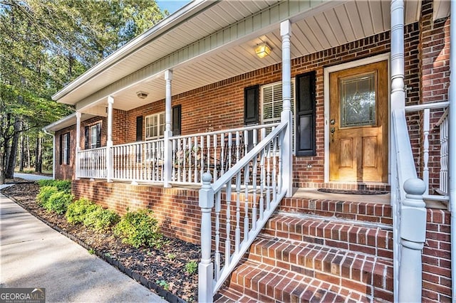 view of exterior entry featuring covered porch