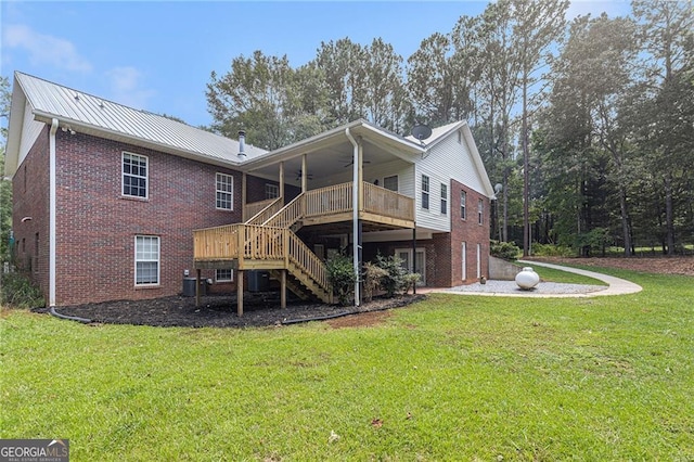 rear view of house with ceiling fan, central AC, a wooden deck, and a lawn