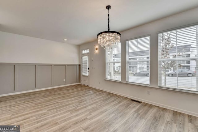 interior space featuring light hardwood / wood-style floors and an inviting chandelier