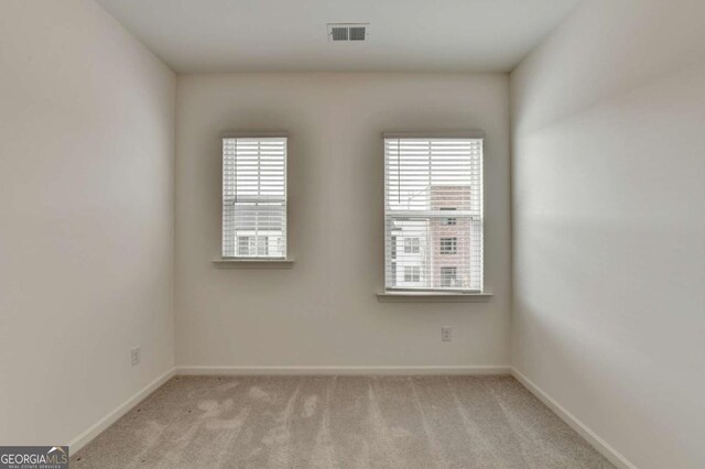 carpeted empty room with a wealth of natural light