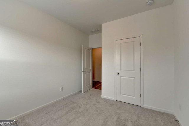 unfurnished bedroom featuring light colored carpet