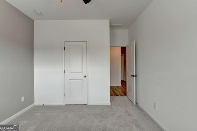 unfurnished bedroom with ceiling fan and light colored carpet