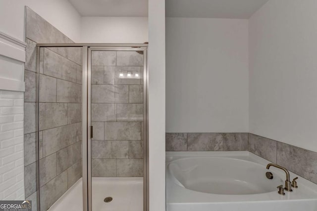 bathroom featuring separate shower and tub