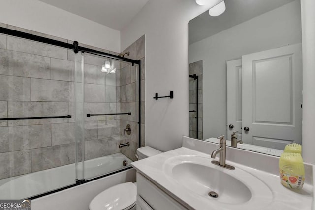 full bathroom with vanity, bath / shower combo with glass door, and toilet