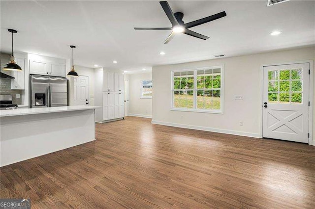 unfurnished living room featuring ceiling fan and dark hardwood / wood-style floors