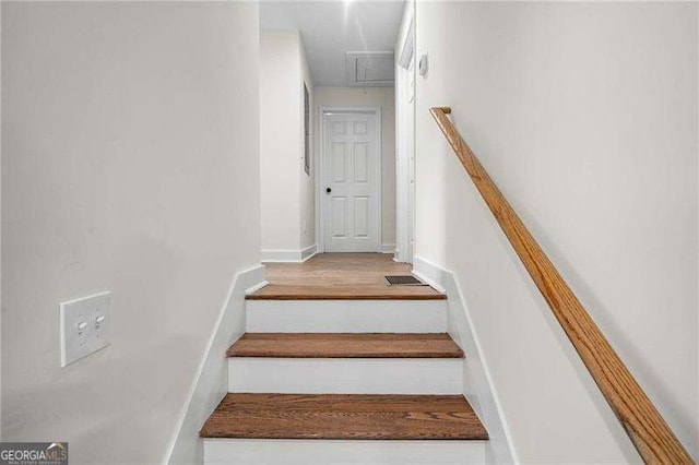 stairs featuring hardwood / wood-style floors