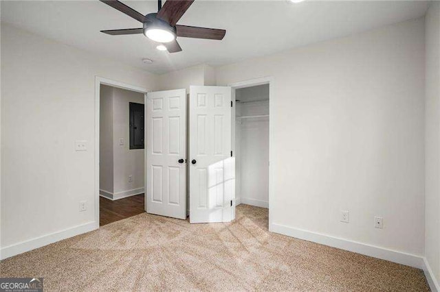 unfurnished bedroom featuring electric panel, ceiling fan, a closet, and light carpet