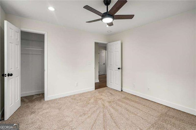 unfurnished bedroom with ceiling fan, a closet, and light carpet