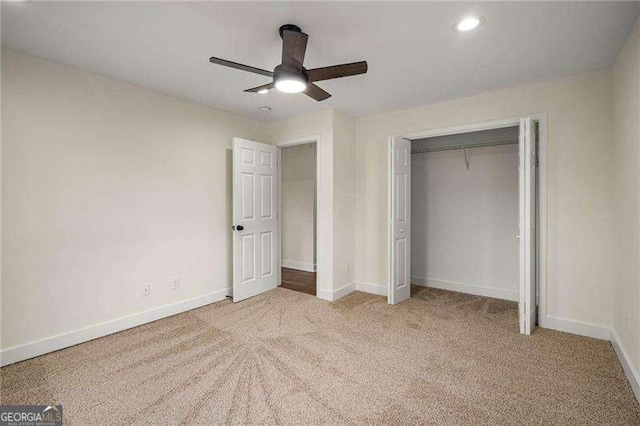 unfurnished bedroom featuring light carpet, a closet, and ceiling fan