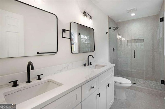 bathroom featuring tile patterned flooring, vanity, toilet, and an enclosed shower