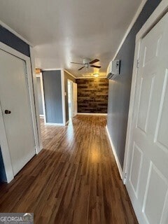 corridor with a wall unit AC and dark hardwood / wood-style floors