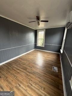 empty room featuring hardwood / wood-style flooring, a wall unit AC, and ceiling fan