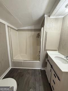 bathroom featuring vanity, a shower with shower door, vaulted ceiling, toilet, and wood-type flooring