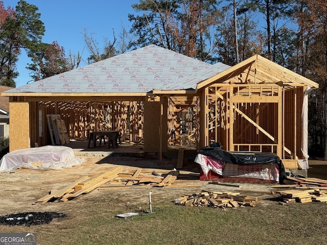 rear view of property featuring a hot tub and a fire pit