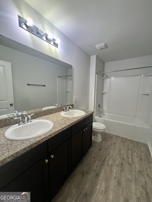 full bathroom featuring shower / bath combination, vanity, hardwood / wood-style flooring, and toilet