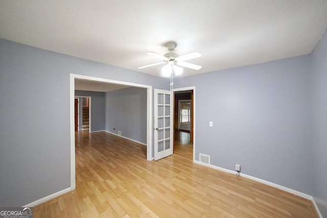 spare room with ceiling fan, light hardwood / wood-style floors, and french doors