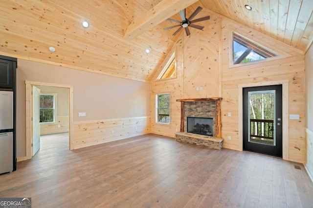 unfurnished living room with high vaulted ceiling, wood-type flooring, a fireplace, beam ceiling, and wood ceiling