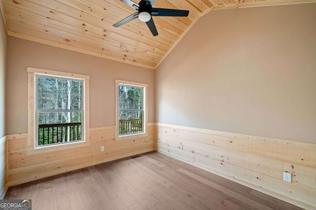 unfurnished room featuring wood ceiling, vaulted ceiling, ceiling fan, wooden walls, and hardwood / wood-style flooring