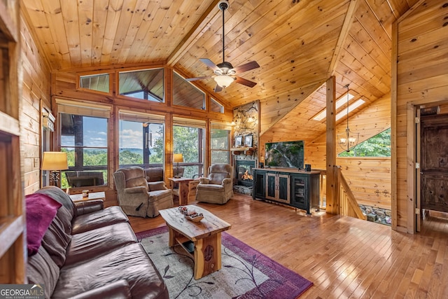 living room featuring wood-type flooring, lofted ceiling, wooden walls, a fireplace, and wood ceiling