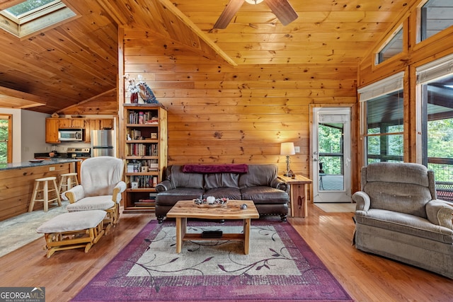 living room with light hardwood / wood-style floors, wooden ceiling, and a skylight